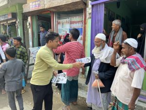 সাধারণ মানুষের হাতে লিফলেট বিতরণ করছেন যুবলীগ নেতা সাত্তার সরকার
