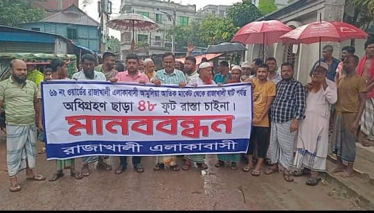 জমি অধিগ্রহণ ছাড়া ৪৮ ফুট রাস্তা চাইনা ক্ষতিপূরণের দাবিতে এলাকাবাসীর মানববন্ধন করেন ।